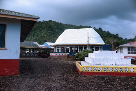 Dorf mit Versammlungshaus und Grab im Vorgarten